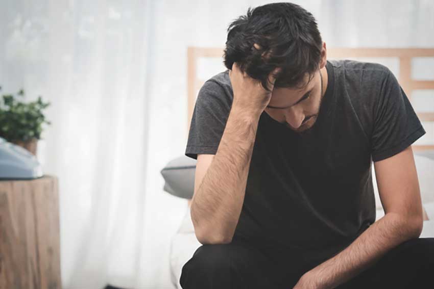 image of a man with his head down looking stressed for the blog about Why doesn't cbd work for me? | cbd dosen't work