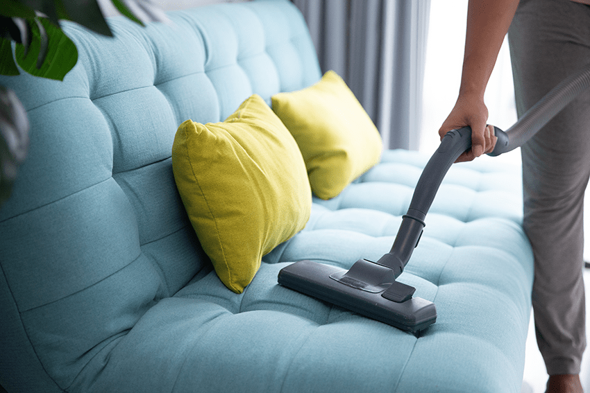 Spring Cleaning with CBD: How Cannabidiol Can Help You Tidy Up and De-Stress | image of someone cleaning the couch