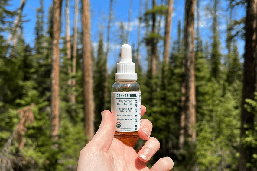 10 Best Hikes In Colorado & How CBD Can Help You Achieve Your Goals 1 An image of a hand holding a cbd tincture oil bottle in the mountains