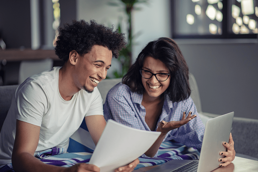image of a couple laughing in front of a laptop for the blog about Exploring the Potential of CBD in Enhancing Healthy Relationships
