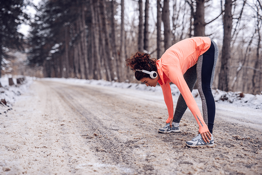Extract Labs Holiday Gift Guide 2023 3 image of a woman stretching before running with headphones on in the winter for blog about Extract Labs Holiday Gift Guide 2023 | CBD Gifts | Pet Gifts | Dog Gifts | Cat Gifts | Gifts for Cat lovers | Gift guide 2023