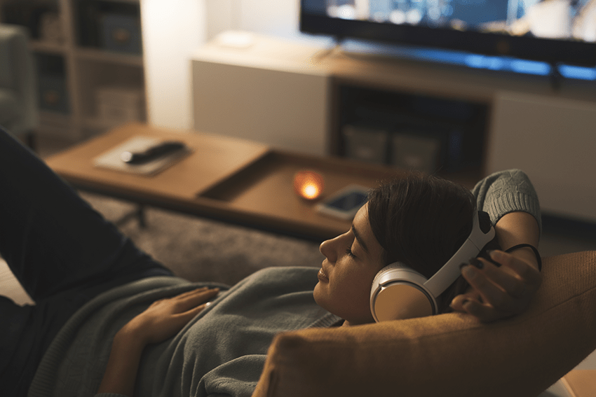 Cannabinoid Guide for Wellness: Discover CBD to Delta 8 2 image of woman relaxing on the couch with headphones on for blog about Cannabinoid Guide for Wellness: Discover CBD to Delta 8