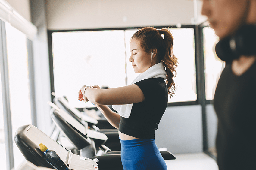 Holistic Health in the New Year: How to Use CBD 5 Ways in 2024 2 image of a woman tracking her progress on a treadmill at the gym for blog about Holistic Health in the New Year: How To Use CBD 5 Ways in 2024