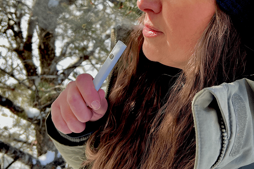 image of a woman smoking a disposable vape for the blog about CBD Vapes 101: A Beginner's Guide to Vape Euphoria
