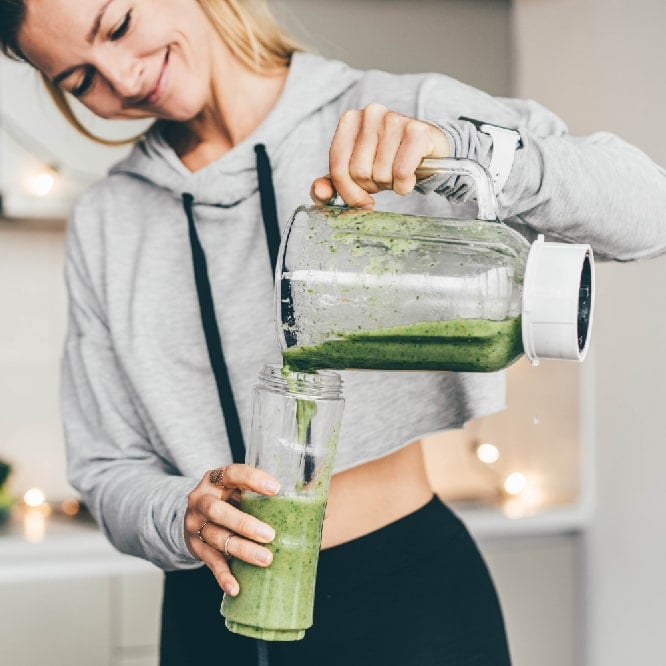 a woman making a smoothie, showing healthy eating habits to support weight management