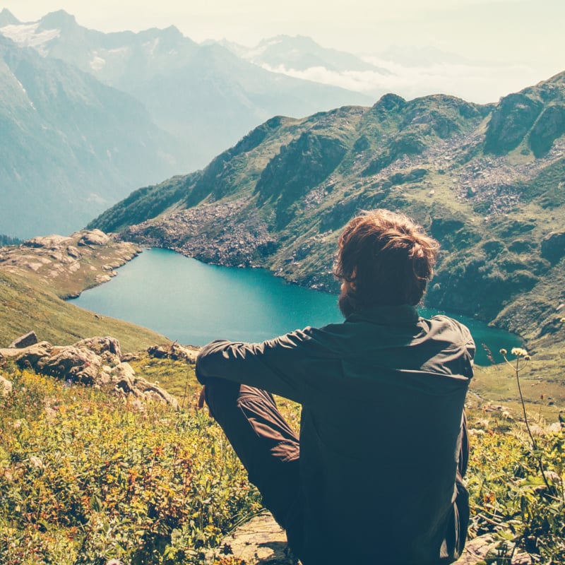 Traveler Man relaxing meditation with serene view mountains and lake landscape Travel Lifestyle hiking concept summer vacations outdoor