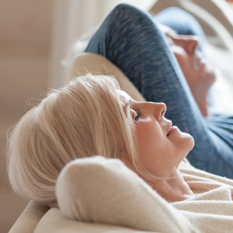 Close up of calm aged couple relaxing on cozy couch