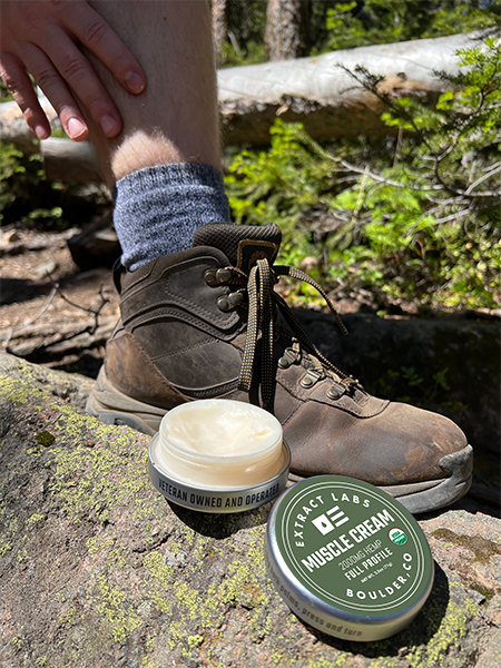 image of hiker pausing to apply Organic Hemp Muscle Cream