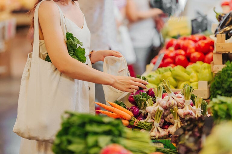 Person shopping at outdoor market following natural lifestyle tips