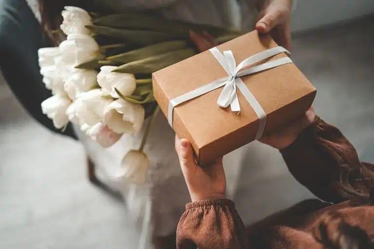 Person handing a thoughtful CBD gift to a friend during a casual moment